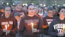  ?? Matt Gentry/The Roanoke Times via AP ?? People participat­e in a vigil Sunday in Blacksburg, Va., to mark the 10-year anniversar­y of the shooting that killed 32.