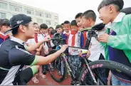  ?? ZHANG KAIHU / FOR CHINA DAILY ?? Volunteers tell children at the Happiness Road Primary School in Donghai county, Jiangsu province, on Monday about the environmen­tal advantages of commuting on bicycles.