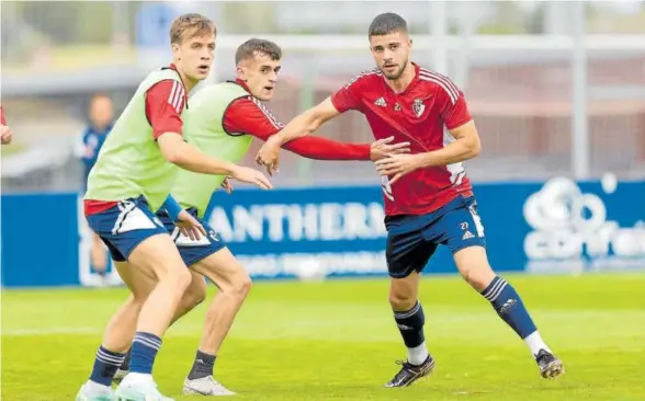  ?? Foto: CA Osasuna ?? Aimar Oroz intenta detener a Iker Muñoz en presencia de Pablo Ibáñez en el entrenamie­nto de ayer en Tajonar.