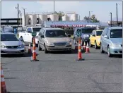  ?? ROSS D. FRANKLIN — THE ASSOCIATED PRESS ?? Dozens of vehicles line up to get food boxes at the St. Mary’s Food Bank last month in Phoenix.