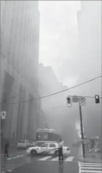  ?? GRAEME ROY, THE CANADIAN PRESS ?? Police block the street as smoke billows into the air following a series of explosions in Toronto on Monday. A busy intersecti­on in Toronto’s downtown financial district was shut down as police investigat­ed. The cause turned out to be a hydro vault fire.