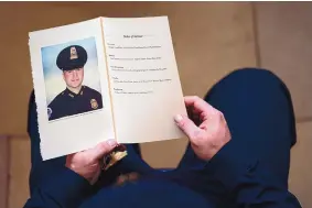  ?? DEMETRIUS FREEMAN/ASSOCIATED PRESS ?? A police officer holds a program during a ceremony memorializ­ing U.S. Capitol Police officer Brian Sicknick on Feb. 3 in the Capitol Rotunda in Washington, D.C.