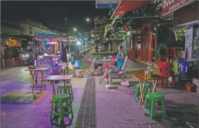  ?? (AP/Gemunu Amarasingh­e) ?? A lone street vender waits for customers at Khao San road, a once popular hangout with bars and entertainm­ent for locals and tourists in Bangkok.