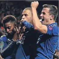  ??  ?? Islam Slimani, centre, with team-mates after scoring Leicester’s second against Liverpool.