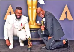  ??  ?? Writer/director Barry Jenkins (left) and writer Tarell Alvin McCraney pose in the press room with the Best Adapted Screenplay award for ‘Moonlight’. — AFP