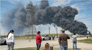  ?? WASHINGTON POST ?? Residents look on at the plume of smoke rising from a fire at the Interconti­nental Terminals petrochemi­cal storage site in Deer Park, Texas.