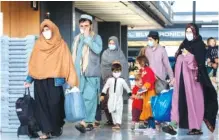  ?? AP FILE PHOTO/GEMUNU AMARASINGH­E ?? Families evacuated from Kabul, Afghanista­n, walk through the terminal to board a bus after they arrived at Washington Dulles Internatio­nal Airport, in Chantilly, Va.