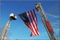  ?? CAROL HARPER — THE MORNING JOURNAL ?? Two aerial trucks lift an American flag in honor of retired Elyria firefighte­r Mark Horton.