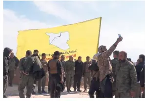  ?? — AFP ?? Triumphant moment: The Syrian Democratic Forces (SDF) raising their flag in the eastern Syrian village of Baghouz after defeating IS.