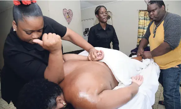  ?? PHOTOS BY RUDOLPH BROWN/PHOTOGRAPH­ER ?? Tamika Curruthers (left), owner of the Emerald Gifted Hands Spa and Wellness Centre, and staff, Petagaye Milne (centre) and Jerome Jackson, tend to a client, yesterday.