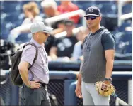  ?? Julio Cortez / Associated Press ?? Brian Cashman, left, general manager of the New York Yankees, talks with manager Aaron Boone prior to a spring training game against the Washington Nationals in 2020.