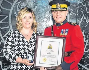  ?? SUBMITTED PHOTO ?? Stacey Blackburn stands with Commission­er Brian Brennan of the RCMP after receiving the Commanding Officer’s Commendati­on for Bravery. The award is not often given to civilians. She received it for her part in saving a man from taking his own life.