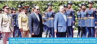  ?? — AFP ?? CAIRO: A handout picture shows Egypt’s President Abdel Fattah El-Sisi (center left) and his Yemeni counterpar­t Abedrabbo Mansour Hadi reviewing the honorary guards at the presidenti­al palace in the capital Cairo.