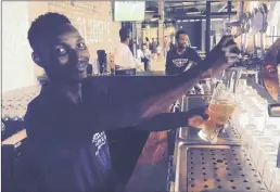  ?? PICTURES: FRANK CHEMALY ?? CRAFTY ALE: Barman Vamumusa Khuzwayo pulls a pint at Robson’s Brewery. This is a second outlet of the craft brewery at the Point.