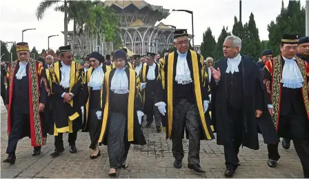  ?? — Bernama ?? Road to justice: (From second right) attorney General tommy thomas, Wong, tengku Maimun and other judiciary officials walking to the Kuching Court Complex for the opening of the legal year in Sabah and Sarawak.