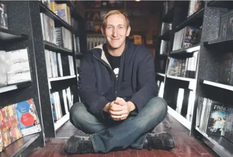  ?? Brenden Neville, Special to The Denver Post ?? Jeff Hahn sits on the floor inside his business, Video One, in Denver. Hahn is attempting to convert the store into a nonprofit to preserve the media collection.