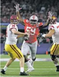  ?? LM OTERO/THE ASSOCIATED PRESS ?? Ohio State defensive lineman Tyquan Lewis, center, closes in on Southern California quarterbac­k Sam Darnold, left, during the Cotton Bowl on Friday in Arlington, Texas. Ohio State won 24-7.