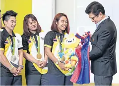  ??  ?? Singha Corporatio­n boss Santi Bhirombhak­di receives a souvenir from the Thai weightlift­ing team which won two gold, one silver and one bronze medals in Rio.