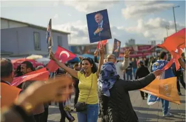  ?? FRANCISCO SECO/AP ?? Supporters of Turkish President Recep Tayyip Erdogan dance last week as they give handouts to commuters in Istanbul. Erdogan’s fate will be decided Sunday when voters in Turkey head back to the polls for a runoff election.