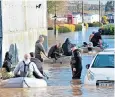  ??  ?? Villagers in Yalding, Kent, negotiate floods after the river Medway burst its banks