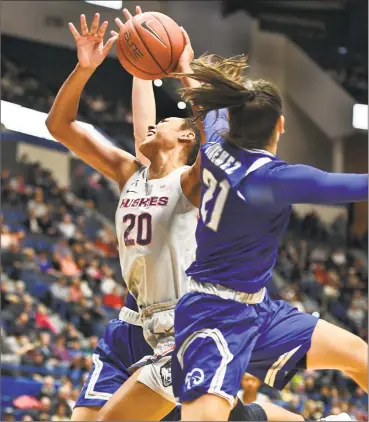  ?? Stephen Dunn / Associated Press ?? UConn’s Mikayla Coombs, left, is fouled by Seton Hall’s Nicole Jimenez in the second half of Saturday’s game in Hartford.