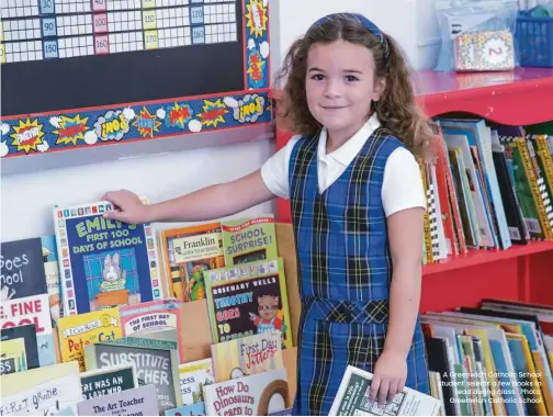  ?? ?? A Greenwich Catholic School student selects a few books to read during class. Photo: Greenwich Catholic School