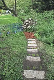  ?? ANGELA PETERSON, MILWAUKEE JOURNAL SENTINEL ?? Paul Malek created a steppingst­one path leading to a blue bridge to his neighbor Lois Schreiter's garden.