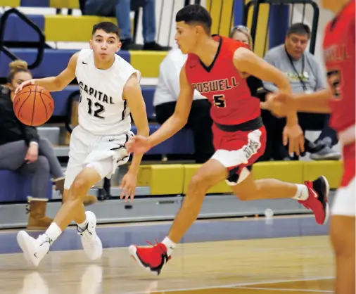  ?? LUIS SÁNCHEZ SATURNO/THE NEW MEXICAN ?? Capital’s Brandon Saiz, left, is guarded by Roswell’s Nate Dutchover on Friday in the Bobby Rodriguez Capital City Tournament. Saiz has taken over as the Jaguars point guard and has had some success as he has gotten more experience at the position.