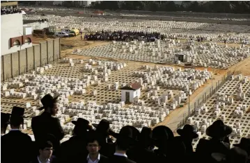  ??  ?? MOURNERS JOSTLE to see the burial site of Rabbi Shteinman, who died on Tuesday at the age of 104, during his funeral ceremony in Bnei Brak yesterday.