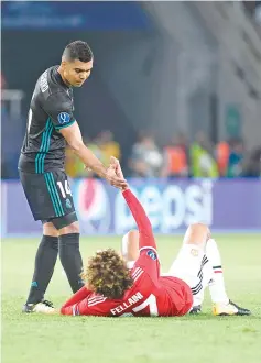  ??  ?? Real Madrid’s Brazilian midfielder Casemiro (L) helps Manchester United’s Belgian midfielder Marouane Fellaini during the UEFA Super Cup football match between Real Madrid and Manchester United on August 8, 2017, at the Philip II Arena in Skopje. - AFP...