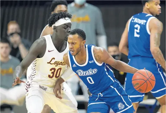  ?? CHARLIE NEIBERGALL/ AP ?? Drake guard DJ Wilkins (0) drives past Loyola forward Aher Uguak (30) during their game in Des Moines, Iowa, on Feb. 14.