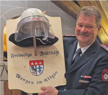  ?? FOTO: SUSANNE MÜLLER ?? Die Feuerwehr überreicht­e ihrem neuen Ehrenkomma­ndanten Dieter Mendel seinen Helm, der ihn über viele Jahre geschützt hat.