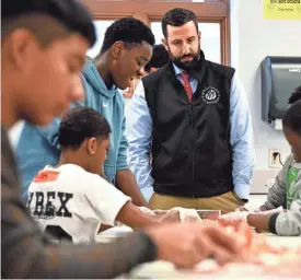  ?? ?? Nativity School of Worcester President Thomas McKenney, who announced the school is campaignin­g to open a girls’ division, watches as eighth grade boys prepare salsa on Friday as part of a Hispanic Heritage Month celebratio­n.