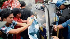  ??  ?? Unruly: Activists scuffling with police during the protest in Manila. — AFP