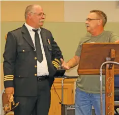  ?? ELISHA MORRISON/THE Saline Courier ?? Recently retired Benton Fire Chief Bill Ford, right, shares stories about retiring fire fighter Phillip Christenbe­rry during Christenbe­rry’s retirement ceremony on Wednesday.