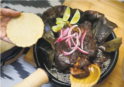  ?? Photos by Liz Hafalia / The Chronicle ?? Dominica Rice-Cisneros of Cosecha, below, adapts her lamb birria, above, using earthenwar­e to replicate pit cooking.