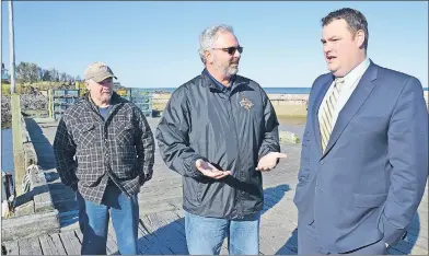  ?? LAWRENCE POWELL ?? Bayshore Harbour Authority president Shawn Everett, centre, and secretary Barry Oliver, left, chat with West Nova MP Colin Fraser at Parker’s Cove where the MP announced $5.7 million in harbour infrastruc­ture funding in the riding.