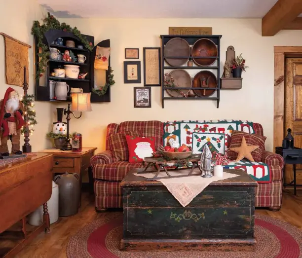  ??  ?? Christmas-themed textiles bring warmth and comfort to the living room. A contempora­ry sofa is at home in the space that’s well appointed with antiques. The trunk acts as a coffee table but also serves as storage for a quilt collection. Toni adorns the wall with a collection of samplers and a bowl rack that Jim made.