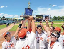  ?? JIM THOMPSON/JOURNAL ?? Portales team members celebrate with their championsh­ip trophy after defeating Hope Christian at Isotopes Park.