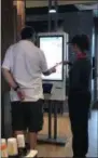  ?? GINGER RAE DUNBAR - DIGITAL FIRST MEDIA ?? A McDonald’s employee helps a customer to use the digital self-order kiosks, one of the new features at the Downingtow­n location.