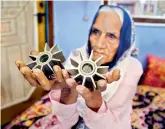 ?? — PTI ?? An elderly woman shows the tails of mortar shells allegedly fired from the Pakistani side of the border, at Sohagpur Powal village on Friday.