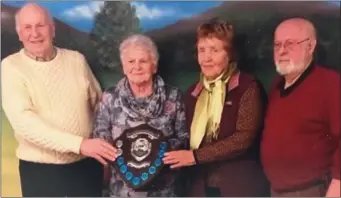  ??  ?? Marie Maher presents the Jackie Maher Perpetual Shield to Clare Wood and Jimmy Flood, winners of the recent pairs competitio­n at Greenhills Bowls Club, alongside chairman Jack Howell.