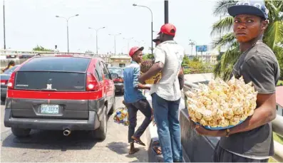  ??  ?? LAGOS: A street vendor looking on as he sells his wares on a road of Lagos. — AFP