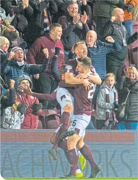  ??  ?? Hearts’ Oliver Bozanic celebrates with Craig Halkett, right, after giving the Tynecastle men the lead