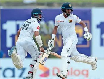  ?? AP ?? Sri Lanka’s Dimuth Karunaratn­e (right) and Lahiru Thirimanne run between the wickets during the fourth day of the first Test against New Zealand in Galle. —