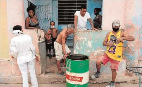  ?? // REUTERS ?? Una enfermera pide en La Habana a una familia que acuda a un centro médico para vacunarse