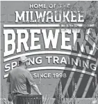  ??  ?? A man walks past a sign Sunday at American Family Fields in Phoenix, the spring training home of the Brewers.