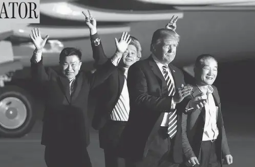  ?? ALEX BRANDON / THE ASSOCIATED PRESS ?? U.S. President Donald Trump walks with former North Korean detainees Tony Kim, Kim Hak-song and Kim Dong-chul at Andrews Air Force Base, Md.