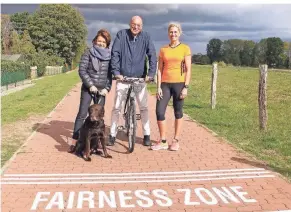  ?? FOTO: STADT MEERBUSC ?? „Stammgäste“am Rheinufer: Matthias Unzeitig Alexandra Schellhorn mit Labrador Bond spazieren und Triathleti­n Iris Hurtz. Ein faires Miteinande­r auf dem Deich - wie hier in Langst-Kierst - ist für alle drei selbstvers­tändlich.