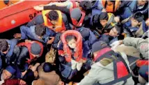  ??  ?? Refugees and migrants board Turkish Coast Guard Search and Rescue ship Umut703 off the shores of Canakkale, Turkey, after a failed attempt of crossing to the Greek island of Lesbos. — Reuters photo